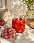 Vela Mermelada de Mandarina de Casa Calma encendida en ambiente lifestyle con fresas y rodajas de naranja