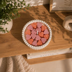 Vista superior de vela aromática con corazones de cera de soja en tonos rosa y terracota – Casa Calma