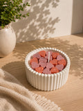 Vela aromática artesanal con corazones de cera rosa en recipiente estriado blanco – Casa Calma