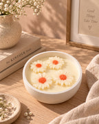 Vista de vela aromática XL con cuatro flores de margarita en mueble – Casa Calma
