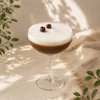 Vela Espresso Martini Casa Calma en copa de cóctel con capa de café y espuma blanca, decorada con granos de cera