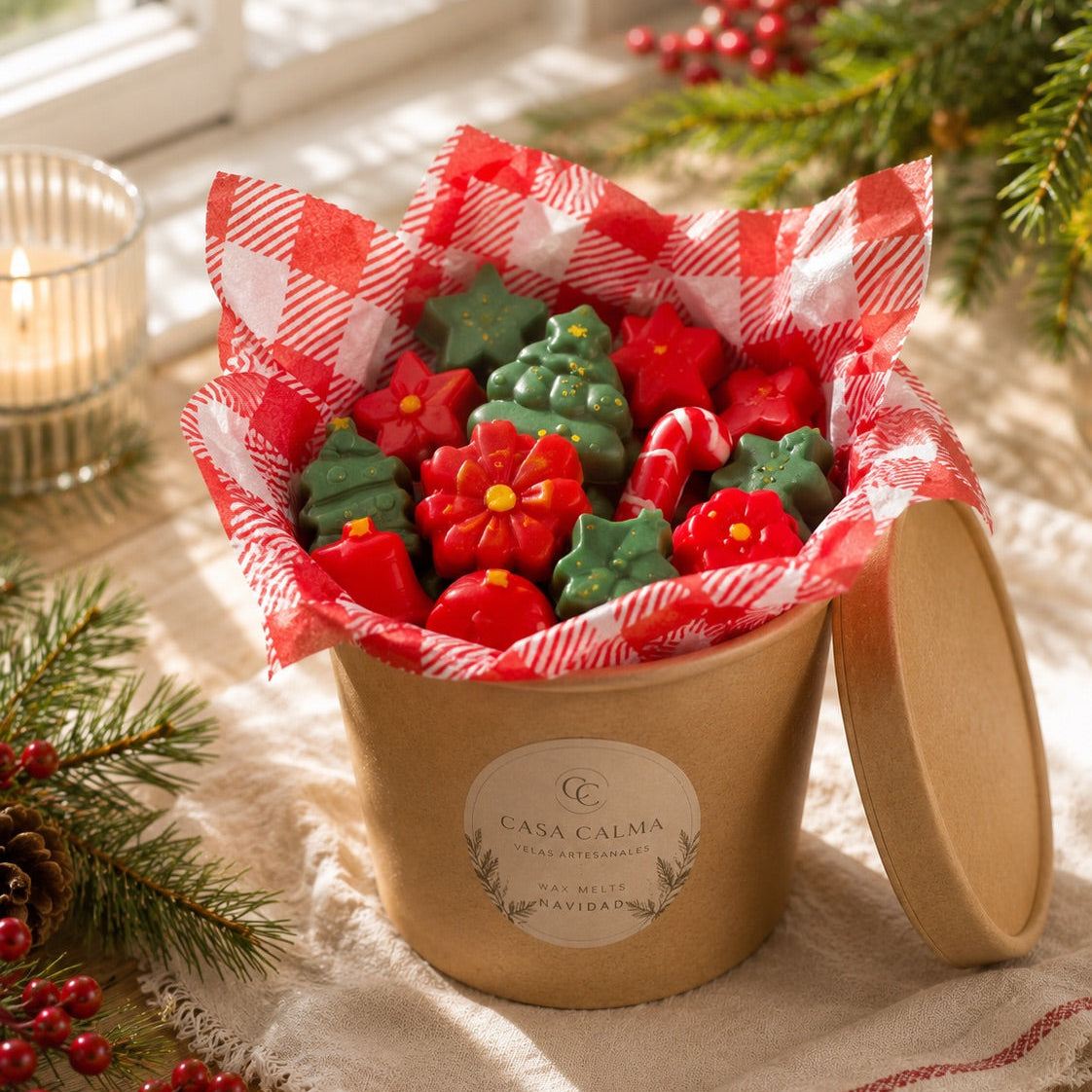 Bote kraft de wax melts navideños de cera de soja rojos y verdes sobre papel de cuadros, Casa Calma